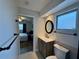 Bathroom with modern vanity, round mirror, and an open view into the bedroom at 2207 Winter Woods Blvd, Winter Park, FL 32792