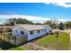 Aerial view of a well maintained one story home with a white exterior, a newer roof, and mature landscaping at 2207 Winter Woods Blvd, Winter Park, FL 32792