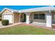 Green front door and brick porch of a tan brick home at 2207 Winter Woods Blvd, Winter Park, FL 32792