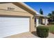 White garage door and portion of tan brick house at 2207 Winter Woods Blvd, Winter Park, FL 32792