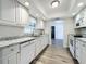 Bright kitchen featuring white cabinetry, granite countertops, stainless steel appliances, and wood-look flooring at 2207 Winter Woods Blvd, Winter Park, FL 32792