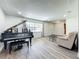 Living room with hardwood floors, a piano, and a comfortable couch at 2207 Winter Woods Blvd, Winter Park, FL 32792