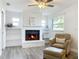 Cozy living room featuring a white brick fireplace with built in shelving and wood flooring at 2207 Winter Woods Blvd, Winter Park, FL 32792