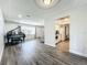 Living room with hardwood floors, a piano, and kitchen access at 2207 Winter Woods Blvd, Winter Park, FL 32792