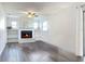 Bright living room features a white brick fireplace, built-in shelves, and wood-look floors at 2207 Winter Woods Blvd, Winter Park, FL 32792