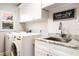 Updated laundry room with white cabinets and granite countertop at 2501 Jennifer Hope Blvd, Longwood, FL 32779