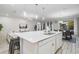 Bright kitchen featuring a large island with seating, white cabinets, stainless appliances, and open layout at 2628 Calistoga Ave, Kissimmee, FL 34741