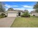 One-story house with a beige garage door and a well-manicured lawn at 2711 Angel Mist Ct, Mascotte, FL 34753