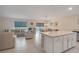 Open kitchen with white cabinets, marble island, and living room view at 2711 Angel Mist Ct, Mascotte, FL 34753