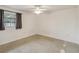 Simple carpeted bedroom with window and ceiling fan at 30845 Westward Ho Ave, Sorrento, FL 32776