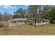 Ranch style home with solar panels and red shutters at 30845 Westward Ho Ave, Sorrento, FL 32776