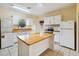 Kitchen with island, white cabinets, and appliances at 30845 Westward Ho Ave, Sorrento, FL 32776