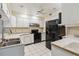 Kitchen with white cabinets, black appliances, and double sink at 30845 Westward Ho Ave, Sorrento, FL 32776