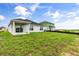 Expansive backyard with a covered patio, lush green grass, and privacy for outdoor enjoyment at 341 Sunbrooke Dr, Groveland, FL 34736