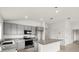 Bright kitchen with stainless steel appliances, gray cabinets, and a granite countertop island at 341 Sunbrooke Dr, Groveland, FL 34736