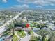 Aerial view of a home with a red location marker, amidst lush greenery, neighboring houses and distant water views at 4130 Floralwood Ct, Orlando, FL 32812