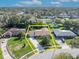 A bright aerial view of a house with a lush green lawn and mature trees clearly outlined in a yellow box at 4130 Floralwood Ct, Orlando, FL 32812