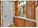 Hall bathroom with wood cabinets, floral wallpaper and light countertop at 4130 Floralwood Ct, Orlando, FL 32812