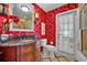 Bathroom featuring red wallpaper, vanity with dark countertop and jacuzzi tub at 4130 Floralwood Ct, Orlando, FL 32812