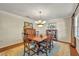 Traditional dining room featuring wooden table and chairs, chandelier, and hardwood floors with area rug at 4130 Floralwood Ct, Orlando, FL 32812