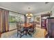 Formal dining room with a large wooden table, patterned rug, and views to the living room at 4130 Floralwood Ct, Orlando, FL 32812