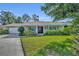 Charming single-story home featuring a brick facade, well-manicured lawn, and double door entry at 4130 Floralwood Ct, Orlando, FL 32812