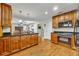 Large kitchen with wood cabinetry, granite counters, and stainless steel appliances flowing into the living area at 4130 Floralwood Ct, Orlando, FL 32812