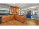 Eat-in kitchen featuring wood cabinets, granite countertops and a view into the blue-themed living space at 4130 Floralwood Ct, Orlando, FL 32812