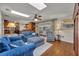 Bright living room with wood floors, blue couches, skylight and open access to the kitchen at 4130 Floralwood Ct, Orlando, FL 32812