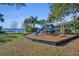 Community playground with slide and swingset near the water, surrounded by lush greenery and seating at 4130 Floralwood Ct, Orlando, FL 32812