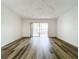 Living room with wood-look floors and sliding glass doors to a patio at 5381 Vineland Rd # S, Orlando, FL 32811