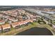 Aerial view of a residential community with houses and pools near a lake at 6156 Broad Oak Dr, Davenport, FL 33837