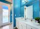 Bathroom with white vanity, blue walls, and access to the pool at 6156 Broad Oak Dr, Davenport, FL 33837