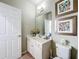 Small bathroom with white vanity, toilet and geometric art at 6156 Broad Oak Dr, Davenport, FL 33837