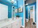 Clean bathroom with white vanity, blue walls, and a walk-in shower at 6156 Broad Oak Dr, Davenport, FL 33837