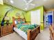 Bedroom with tropical theme, full-size bed, and custom mural at 6156 Broad Oak Dr, Davenport, FL 33837