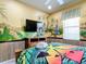 Bedroom with a tropical mural, full-size bed, and flat-screen TV at 6156 Broad Oak Dr, Davenport, FL 33837