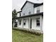 Two-story house featuring gray and white exterior, front porch, and landscaped lawn at 62 W Esther W St, Orlando, FL 32806