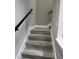 Modern staircase with wood-look treads and black railing at 62 W Esther W St, Orlando, FL 32806