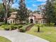 Two-story house with tile roof, landscaped yard, and circular driveway at 7718 Flemingwood Ct, Sanford, FL 32771