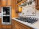 Modern kitchen features double ovens and gas cooktop with granite countertops at 7718 Flemingwood Ct, Sanford, FL 32771