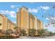Multi-story residential building with yellow exterior and palm trees at 8101 Resort Village Dr # 31308, Orlando, FL 32821
