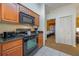 Fully equipped kitchen with black appliances and wood cabinetry at 8101 Resort Village Dr # 31308, Orlando, FL 32821