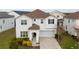 Two-story house with a white exterior, brown roof, and a paved driveway at 8953 Hilton Ridge Ave, Kissimmee, FL 34747