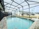 Inviting screened pool with a basketball hoop and plenty of lounge chairs at 8953 Hilton Ridge Ave, Kissimmee, FL 34747