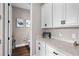 Bright laundry room with white cabinets and quartz countertops at 9203 Neher St, Orlando, FL 32827