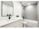 Modern bathroom with grey tile, white vanity, and black matte fixtures at 9657 Pacific Pines Ct, Orlando, FL 32832