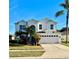 Two-story house with a three-car garage and palm trees in the front yard at 9657 Pacific Pines Ct, Orlando, FL 32832