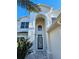 Two-story house front entrance with arched entryway and double door at 9657 Pacific Pines Ct, Orlando, FL 32832