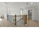 Bright upper hallway with modern wooden railing and light wood flooring at 9657 Pacific Pines Ct, Orlando, FL 32832